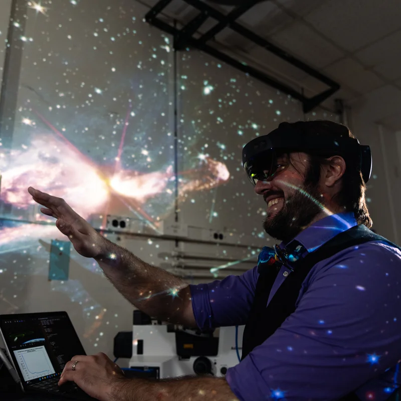 Man wearing augmented reality goggles and stars projected over him.
