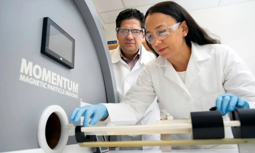 Researchers wearing protective glasses and gloves working