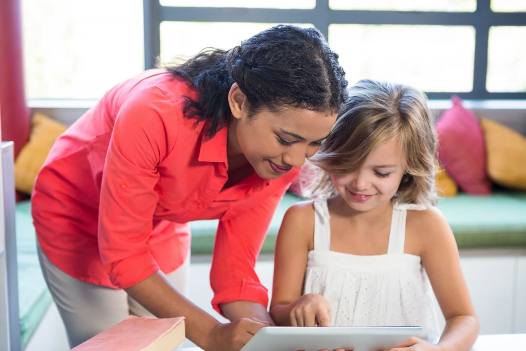 A teacher and elementary student using a tablet