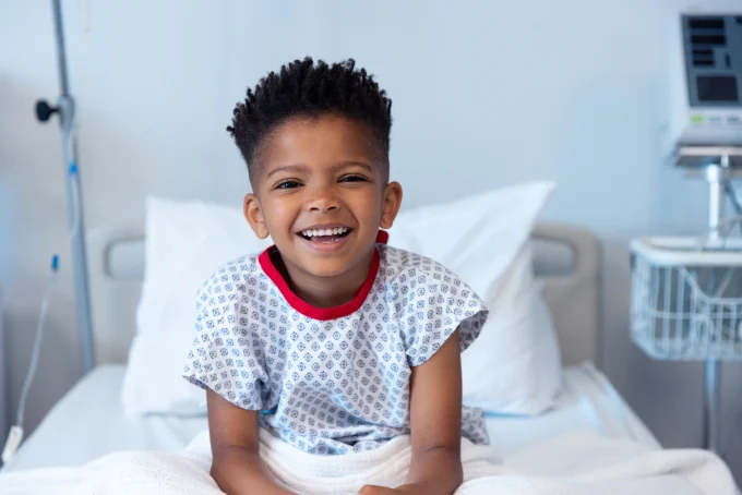 Smiling child sitting on hospital bed