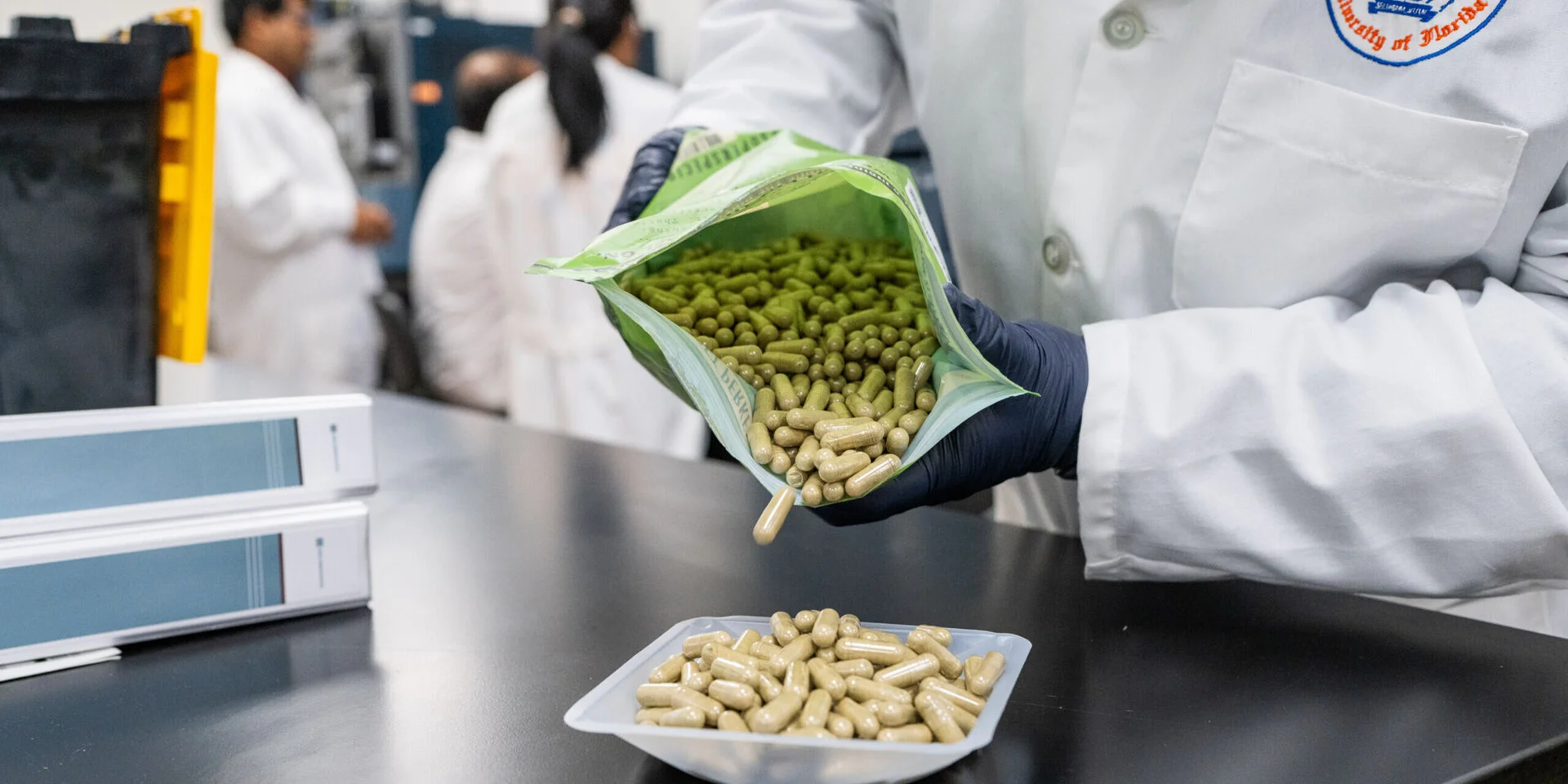 A researcher dumps supplement capsules on a table.