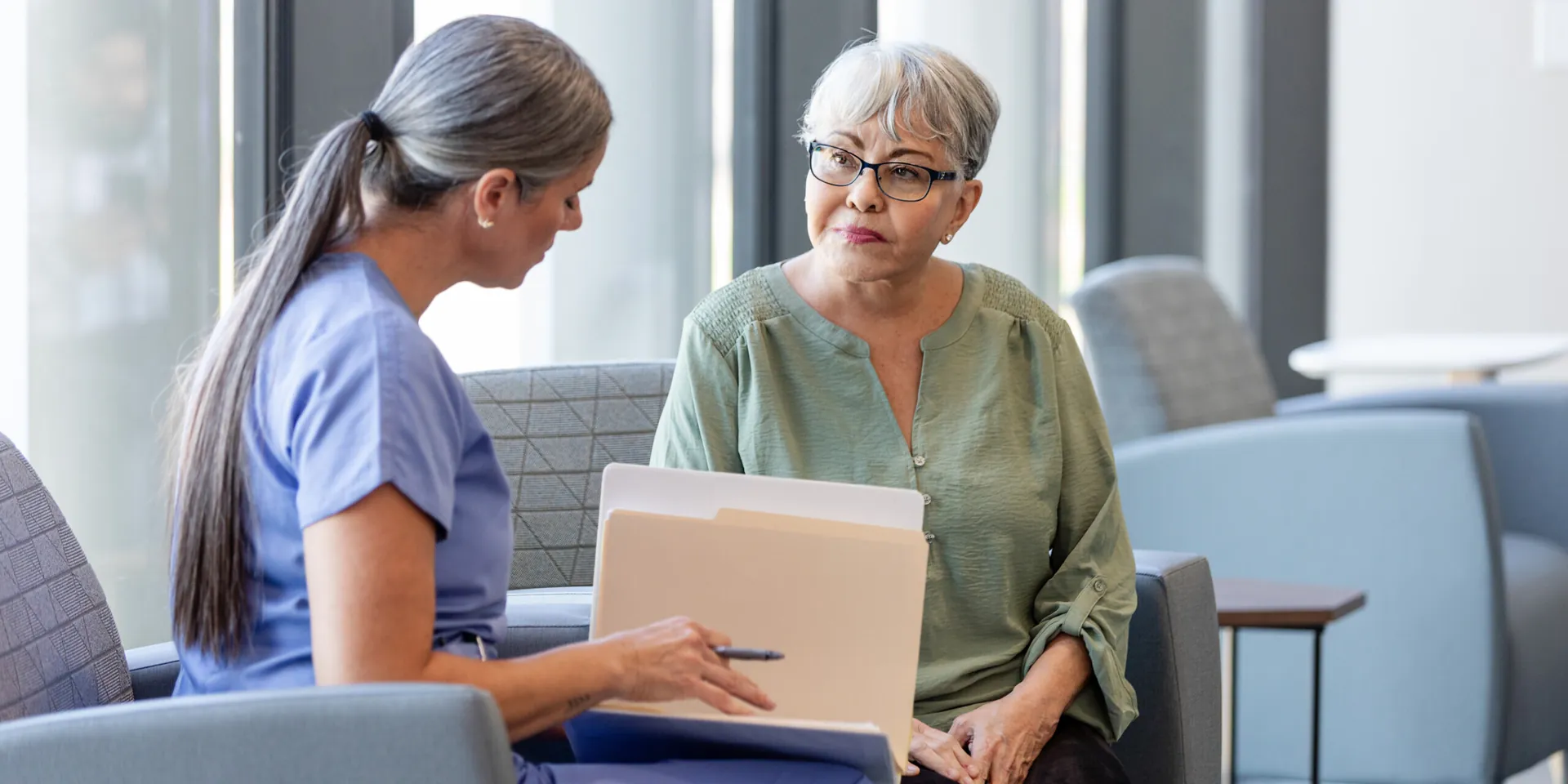 A doctor sits with her elderly patient